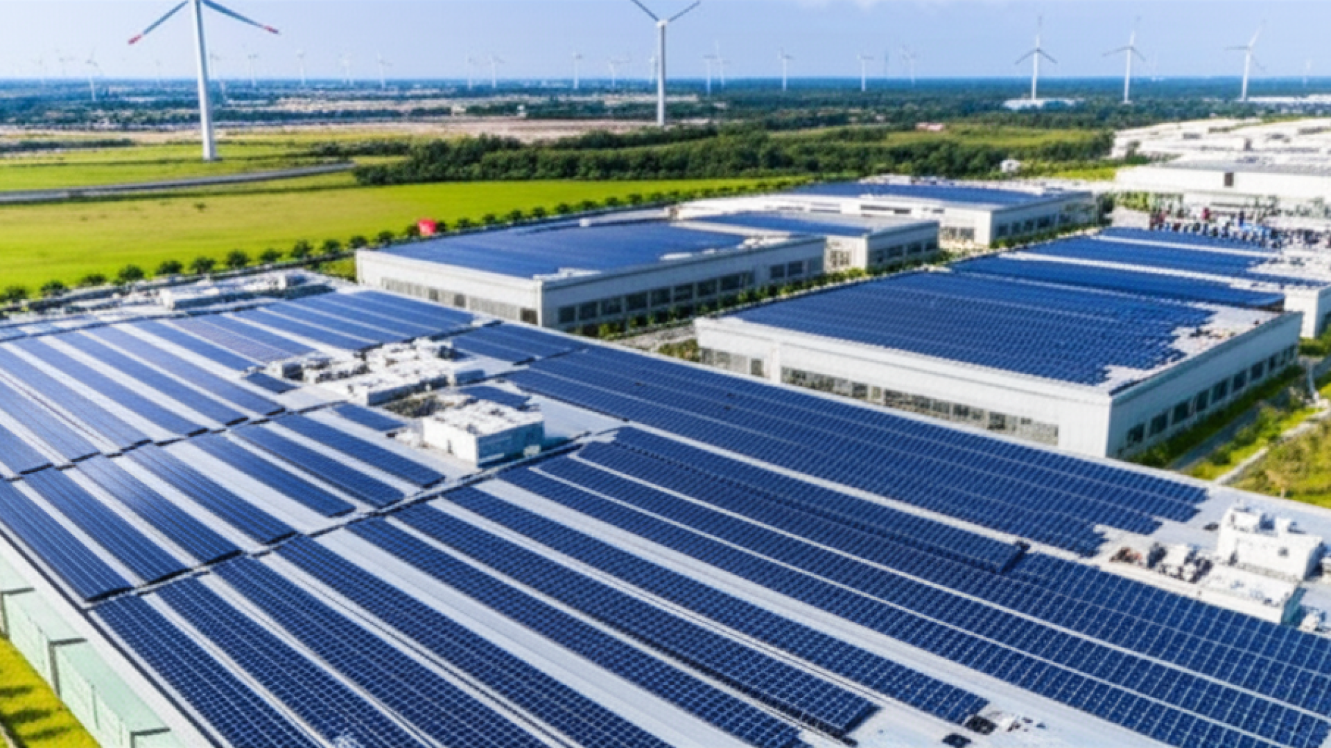 A vast high-tech manufacturing campus with extensive solar panel arrays on all rooftops, surrounded