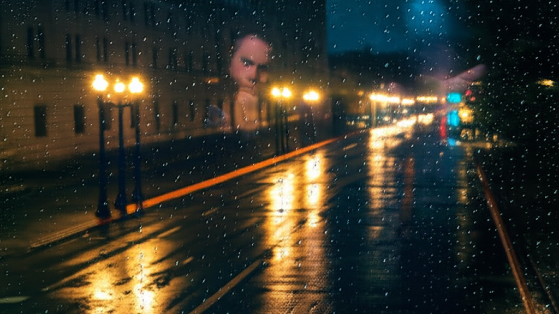 A high-angle shot of a rain-slicked Washington D.C. street at night, looking through a window with s